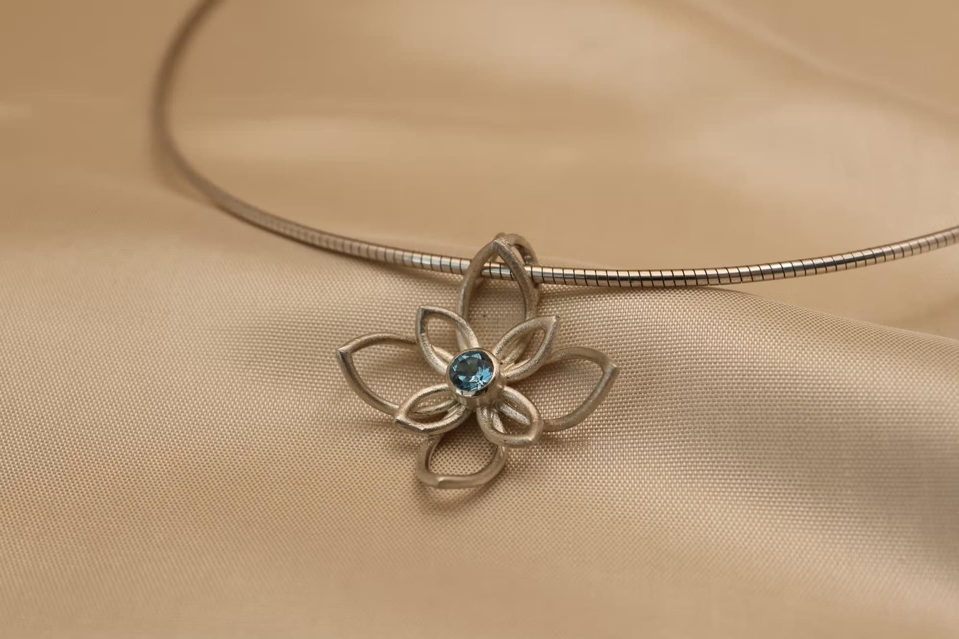 Zilveren hanger geïnspireerd op de lotus met een topaas